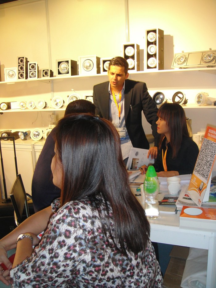 People talking around a table beside the lighting display.