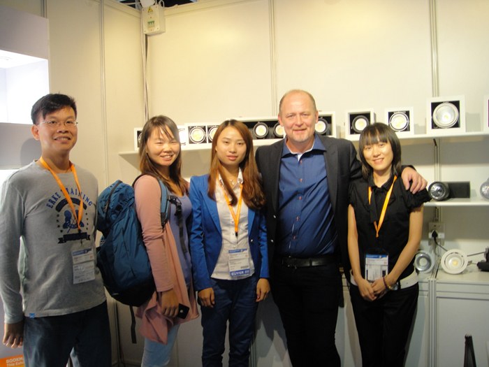 Five people standing beside the lighting display shelves.