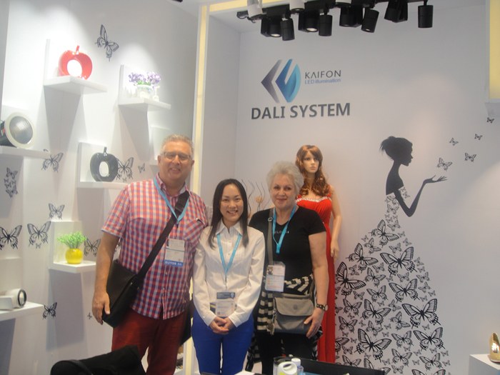 Three people standing in front of the lighting display.