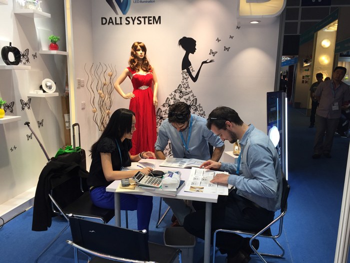 People reviewing documents at an exhibition meeting table.