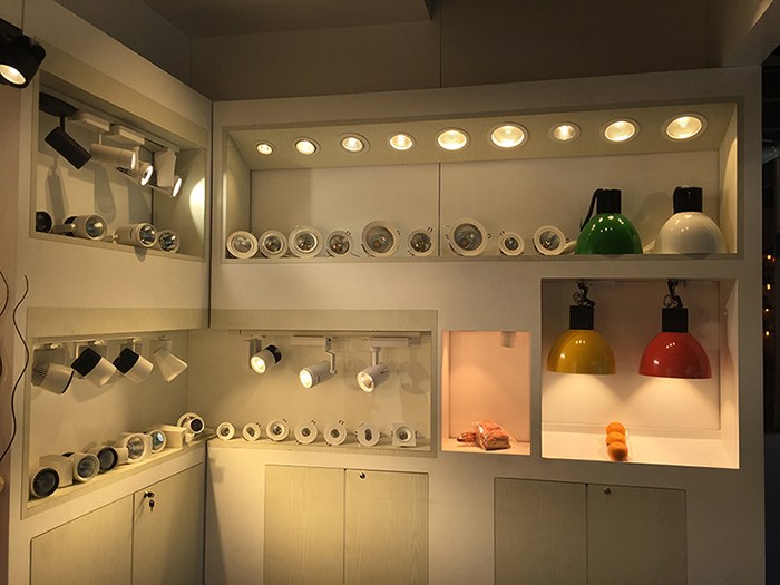 Illuminated display shelves showing downlights and pendant luminaires.