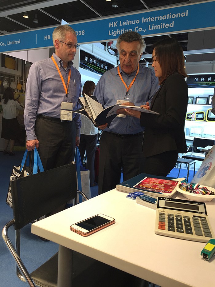 People reading documents at the KAIFON exhibition stand.