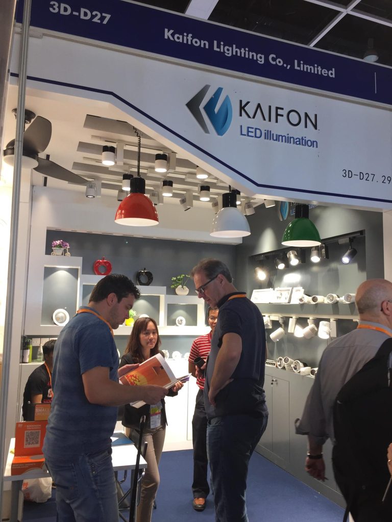 People talking beneath the KAIFON exhibition stand sign.