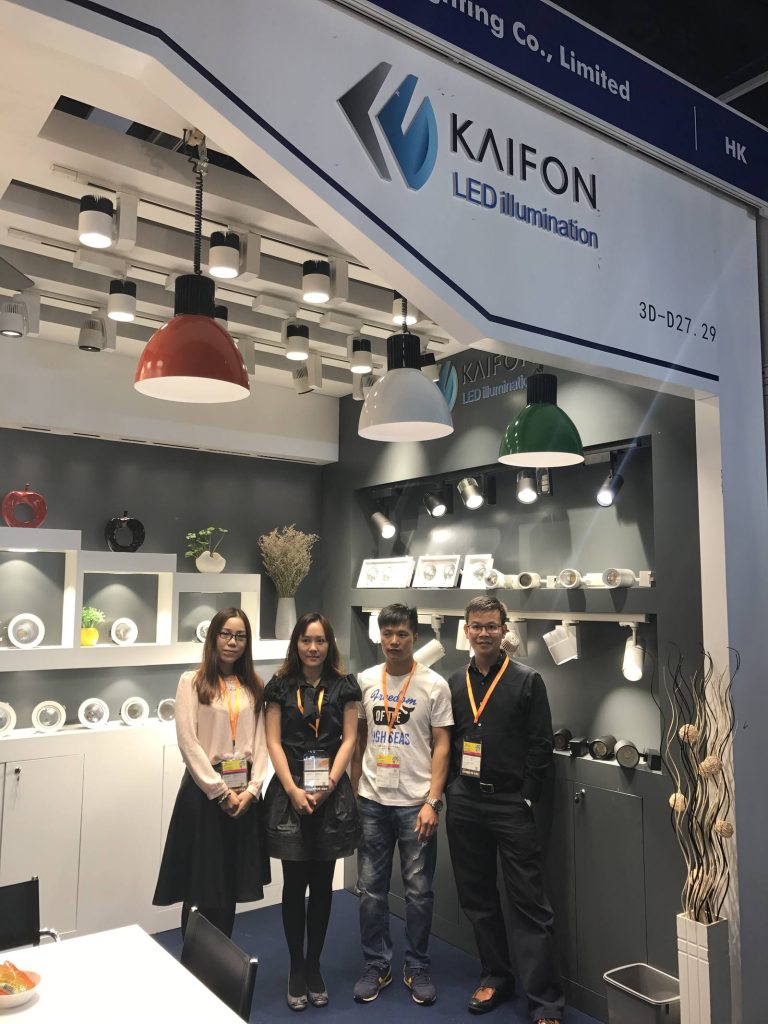 A group standing beneath the KAIFON sign beside the lighting display.