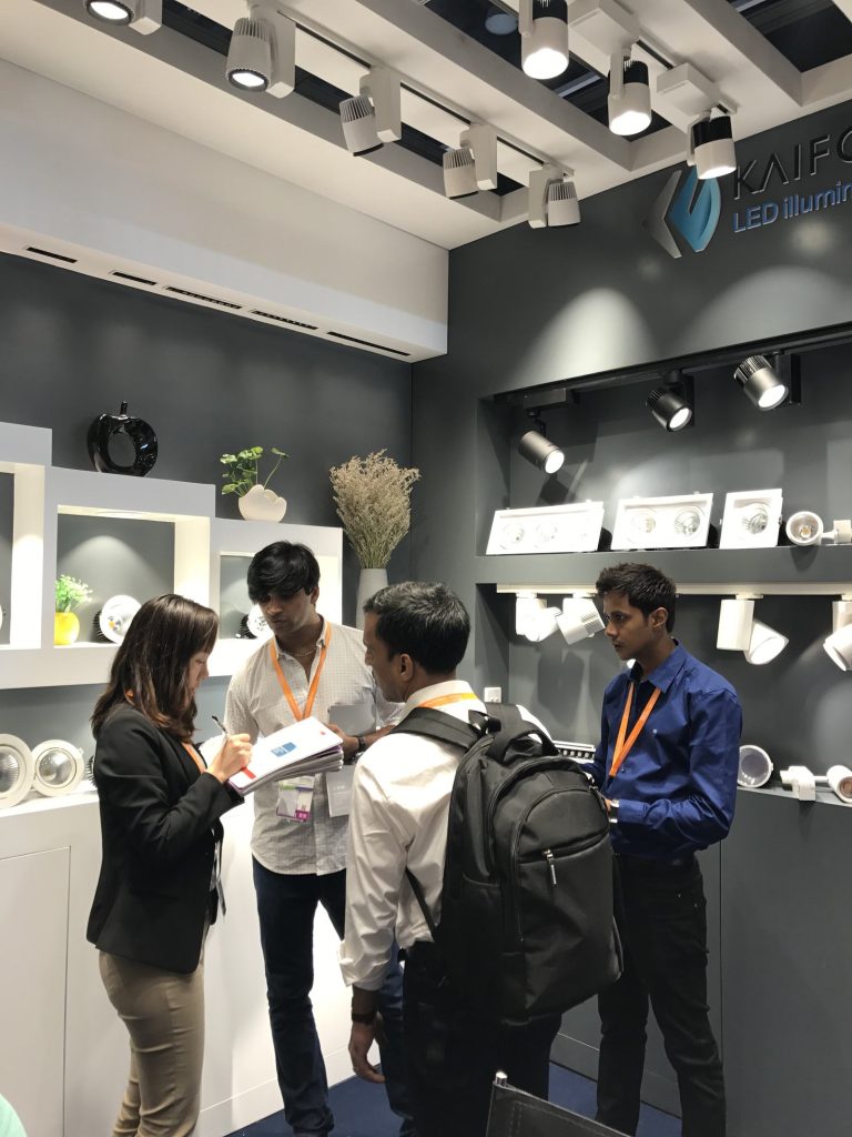 People gathered around a meeting table inside the KAIFON stand.