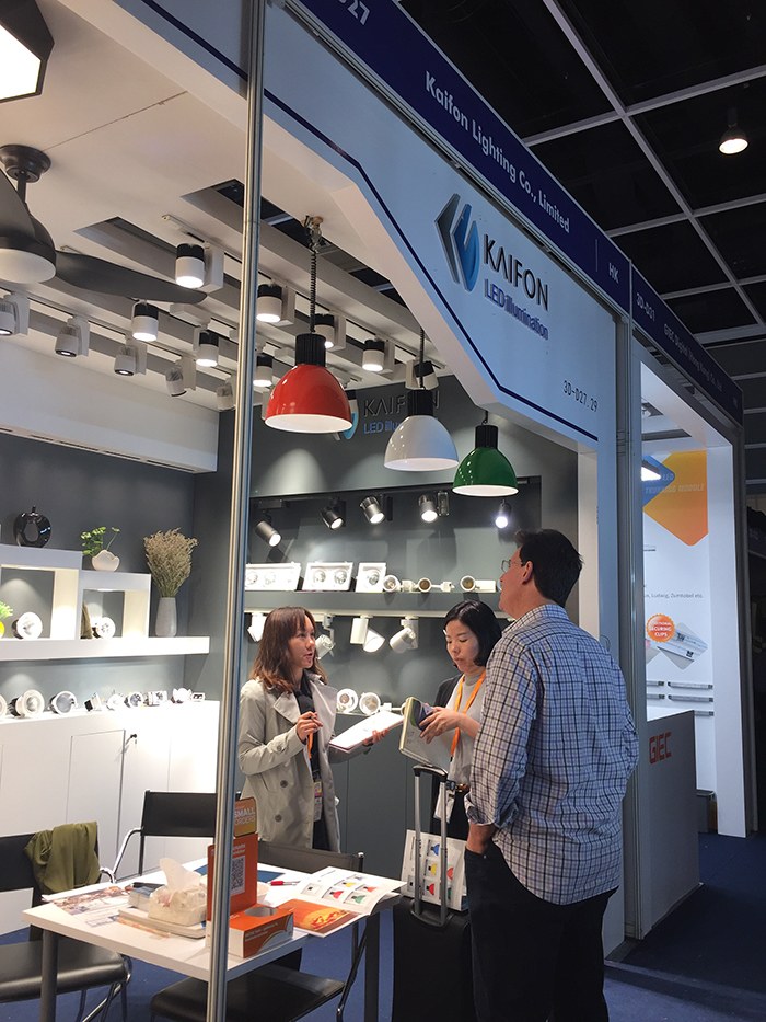 People talking beside a meeting table at the KAIFON stand.