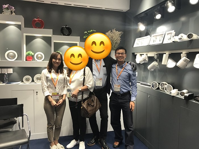 Four people standing in front of the KAIFON lighting display.