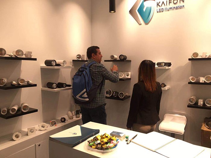 People examining luminaires on the KAIFON display shelves.