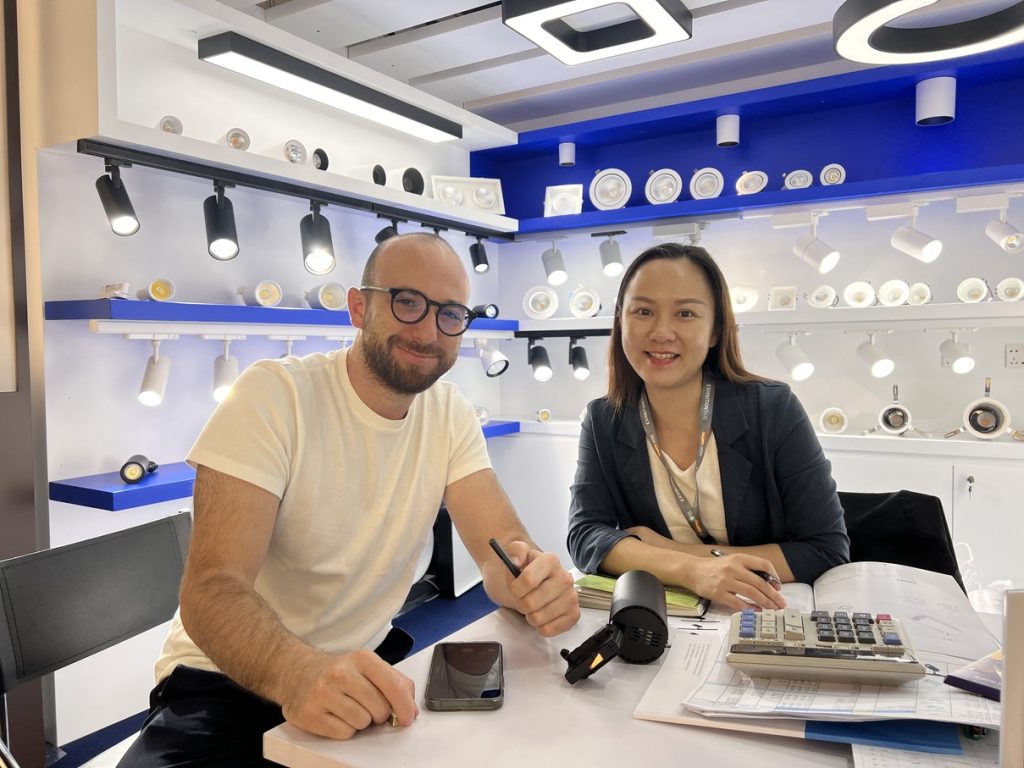 Two people seated at a table inside the KAIFON stand.