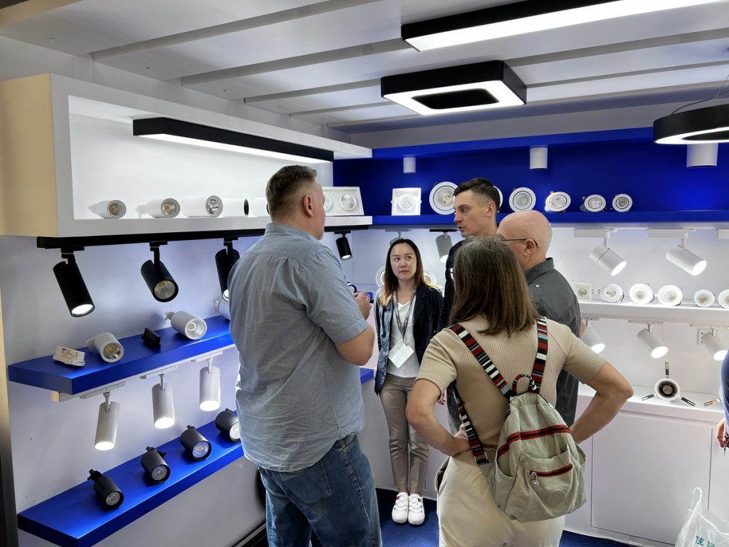 People gathered in front of the blue and white lighting display.