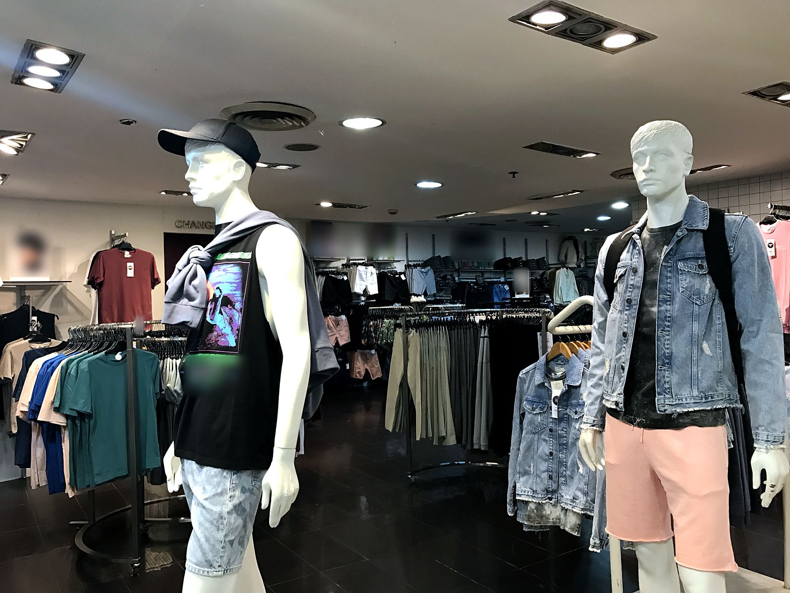 Three-head grille lights and round recessed downlights over a menswear sales floor